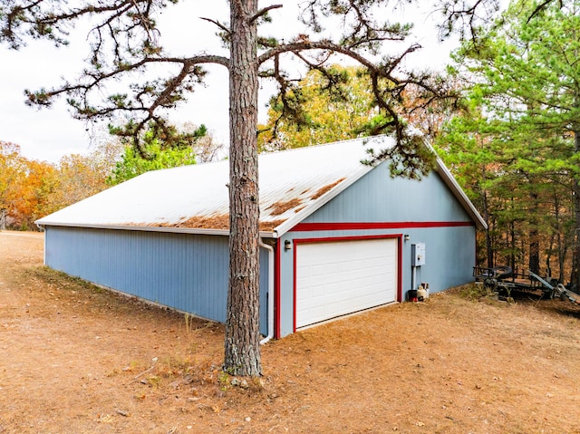 detached garage featuring dirt driveway