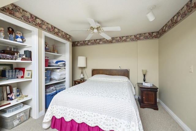 carpeted bedroom with baseboards and a ceiling fan