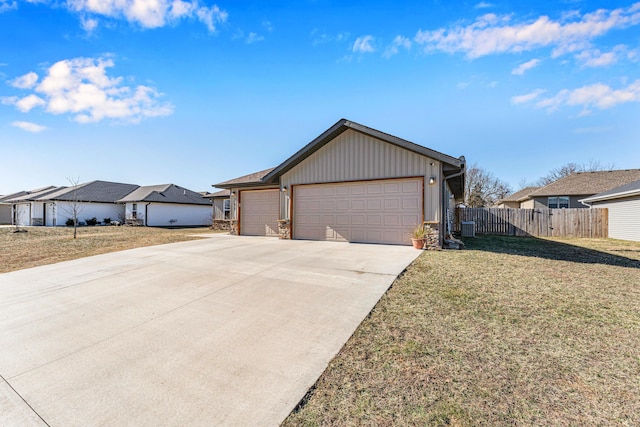 view of front of property with driveway, a residential view, an attached garage, fence, and a front yard