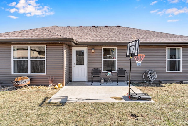 back of property featuring a yard, a patio, and roof with shingles