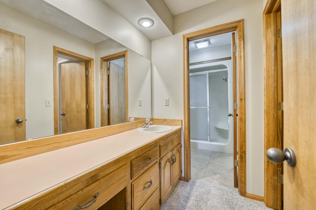 bathroom with a shower with shower door and vanity