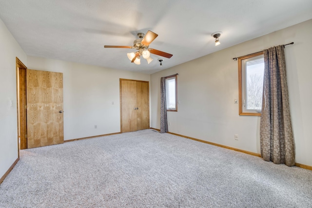 unfurnished bedroom featuring carpet floors, a closet, ceiling fan, and baseboards