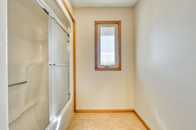 full bath with bath / shower combo with glass door, baseboards, and tile patterned floors