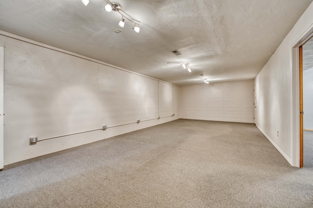 carpeted empty room with visible vents and a textured ceiling