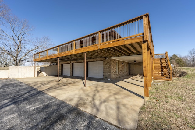 view of patio with driveway, stairway, an attached garage, a deck, and a carport