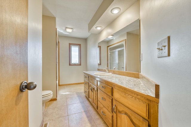 full bathroom featuring a shower with shower door, toilet, vanity, baseboards, and tile patterned floors