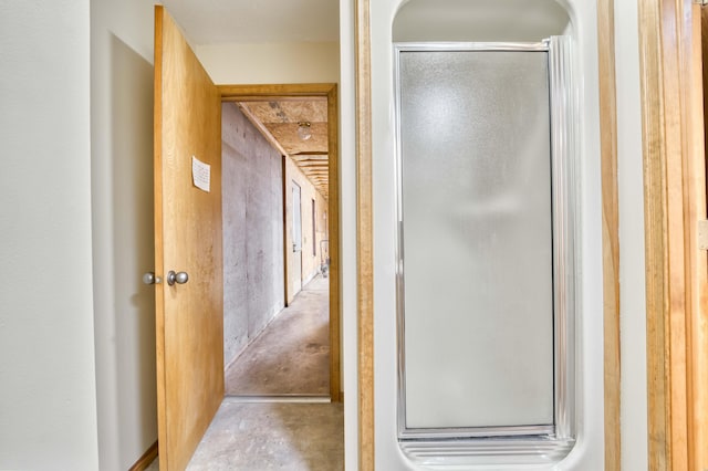 bathroom featuring an enclosed shower and unfinished concrete floors