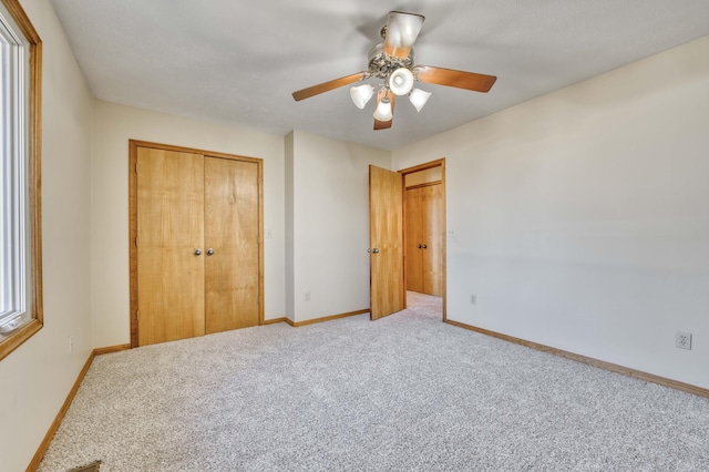 unfurnished bedroom featuring ceiling fan, carpet floors, a closet, and baseboards