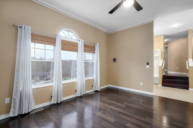 unfurnished room with baseboards, visible vents, and wood finished floors