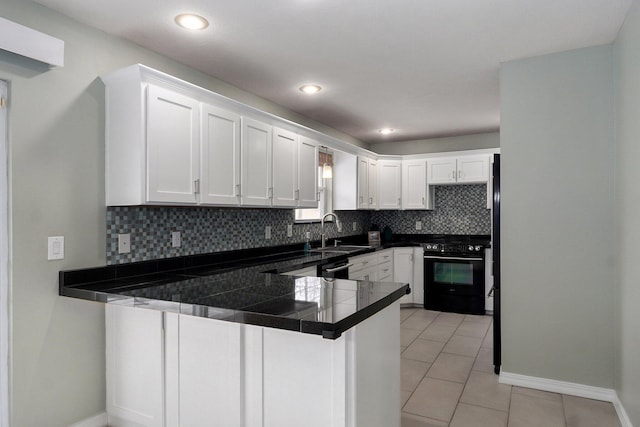 kitchen featuring decorative backsplash, gas stove, light tile patterned flooring, a sink, and a peninsula