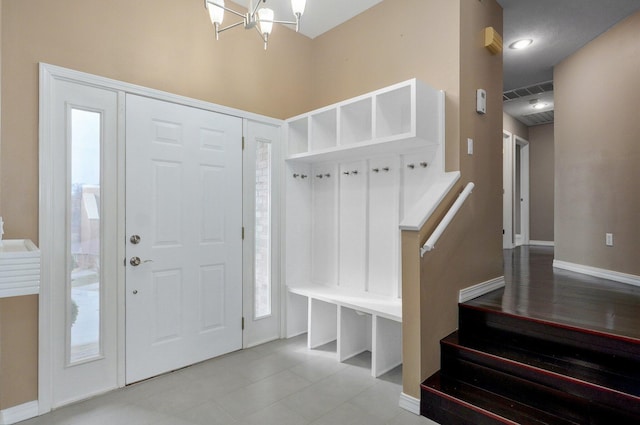 mudroom featuring light tile patterned floors, visible vents, baseboards, and an inviting chandelier