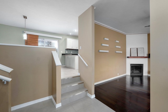 stairs featuring a fireplace, baseboards, and wood finished floors