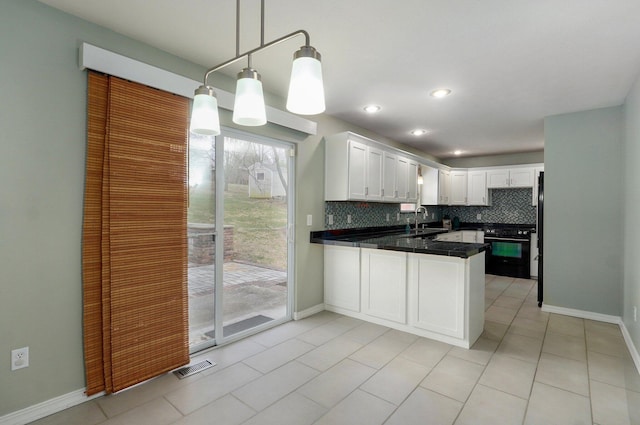 kitchen with white cabinets, decorative backsplash, a peninsula, black gas stove, and a sink