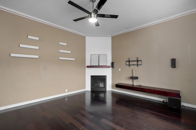 unfurnished living room featuring a fireplace, ornamental molding, ceiling fan, wood finished floors, and baseboards