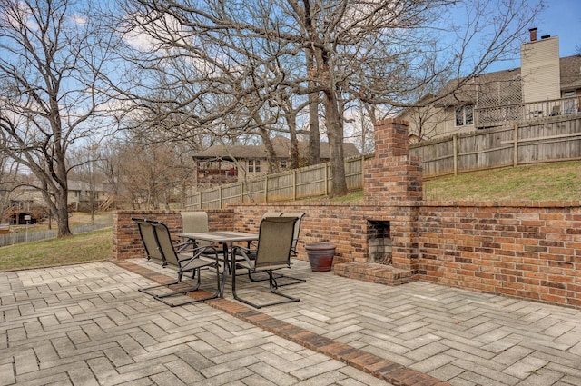 view of patio / terrace featuring an outdoor brick fireplace, fence private yard, and outdoor dining area