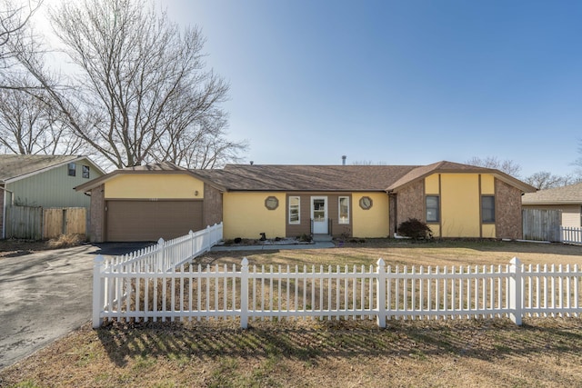 view of front of home featuring a garage, concrete driveway, a fenced front yard, and stucco siding