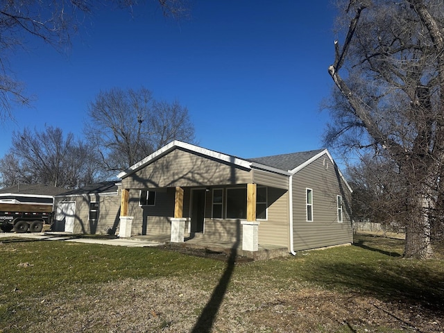 view of front of house featuring covered porch, a front lawn, and roof with shingles