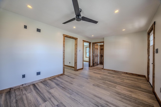 unfurnished bedroom with baseboards, multiple windows, wood finished floors, and recessed lighting