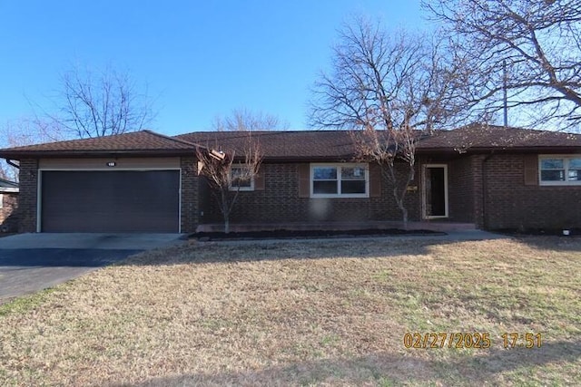 ranch-style house featuring brick siding, an attached garage, driveway, and a front yard