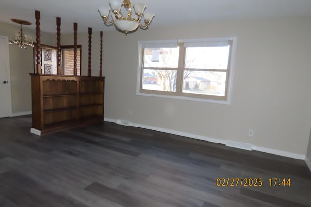 unfurnished dining area featuring visible vents, a notable chandelier, and dark wood finished floors