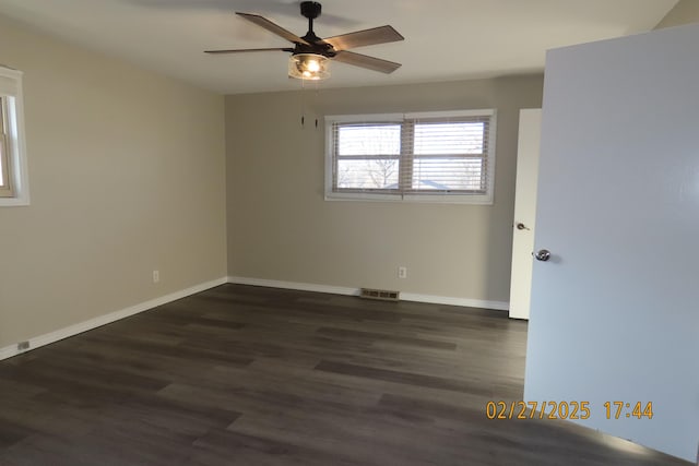 unfurnished room with a ceiling fan, dark wood-type flooring, baseboards, and visible vents