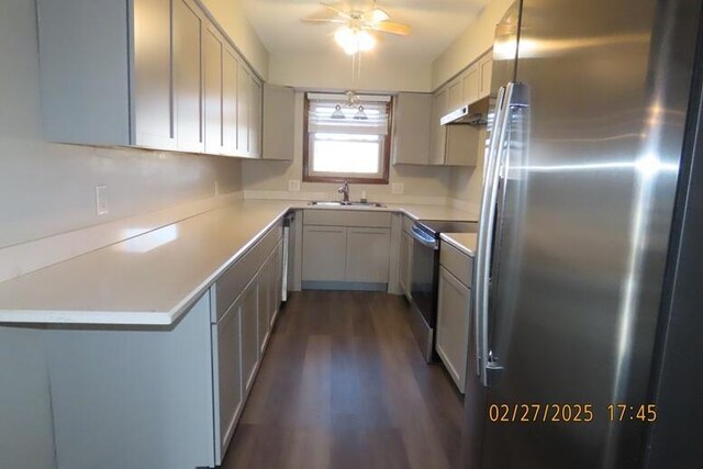 kitchen with a sink, range with electric stovetop, dark wood-style floors, freestanding refrigerator, and light countertops