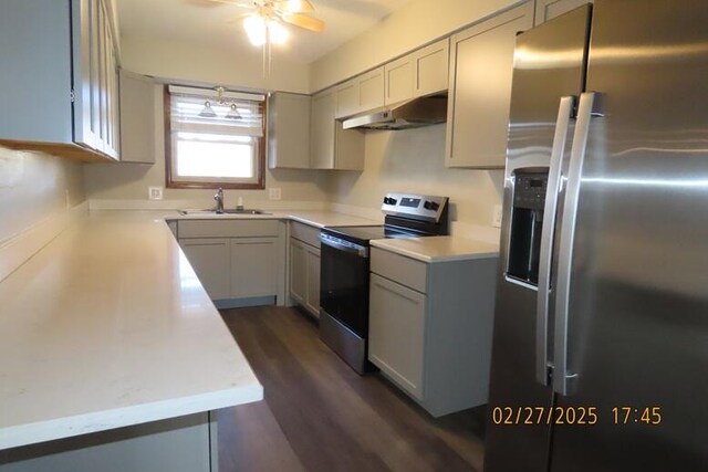 kitchen with a sink, light countertops, under cabinet range hood, and stainless steel appliances