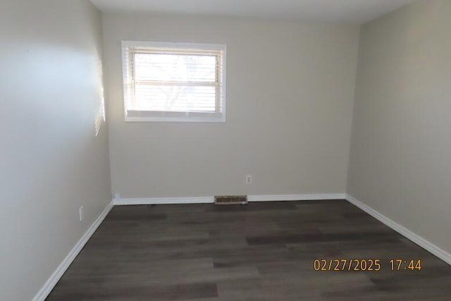 unfurnished room featuring visible vents, baseboards, and wood finished floors