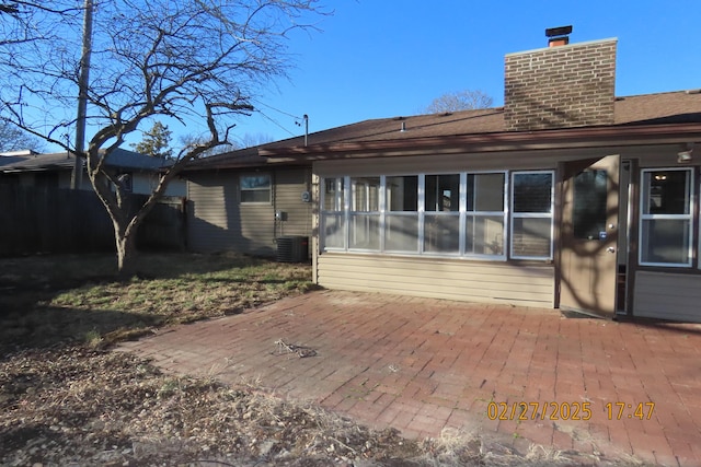 rear view of house with a patio area, central AC, and a chimney