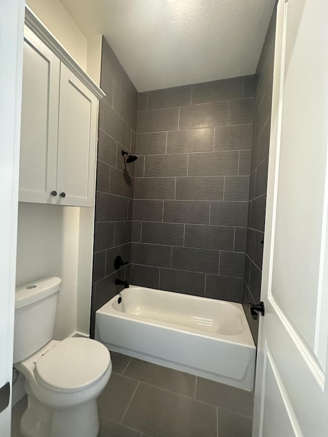 full bathroom featuring a textured ceiling, bathtub / shower combination, toilet, and tile patterned floors