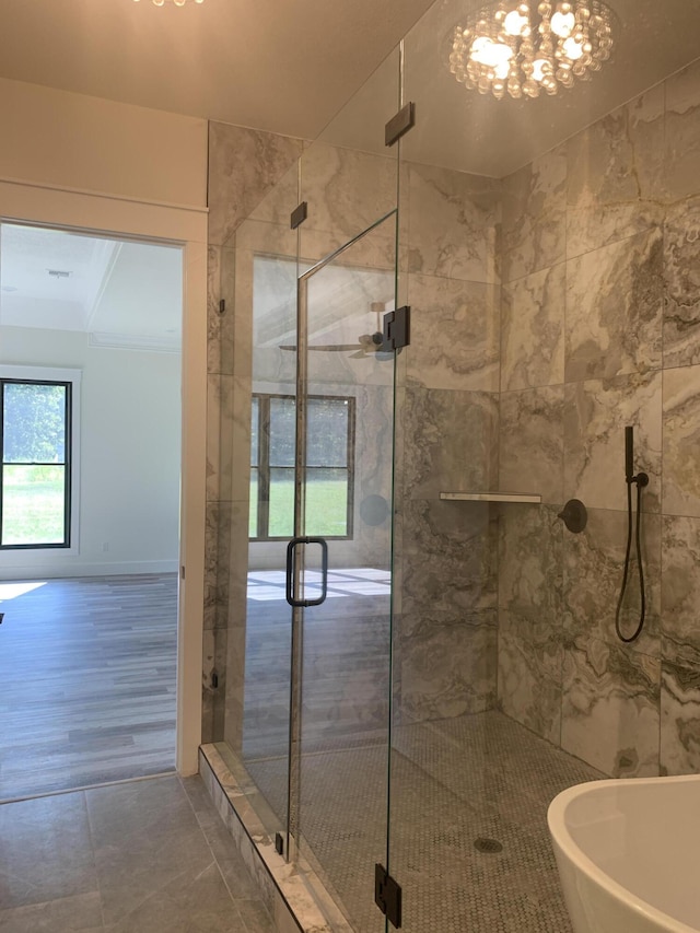 bathroom featuring a stall shower, a chandelier, and a soaking tub