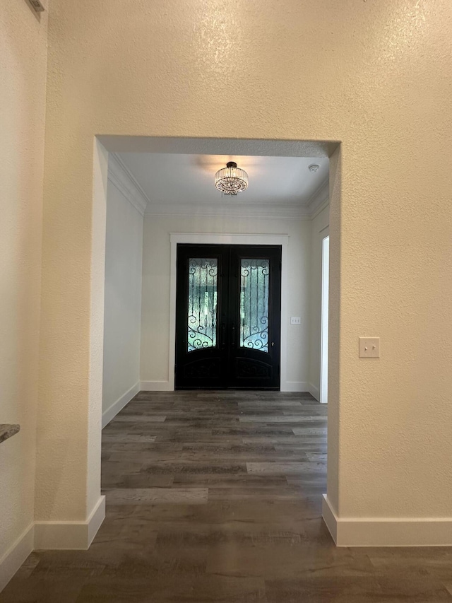 foyer featuring dark wood-style floors, baseboards, and crown molding