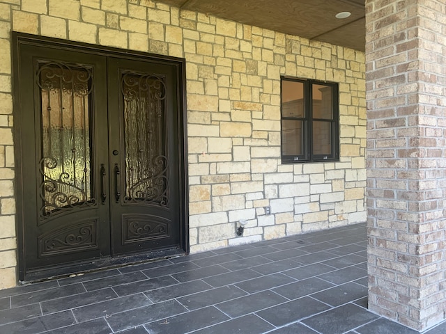 property entrance with french doors and brick siding