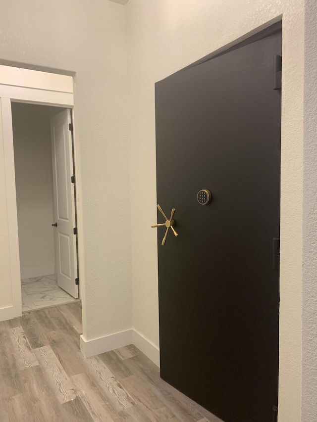 hall featuring baseboards and wood finished floors