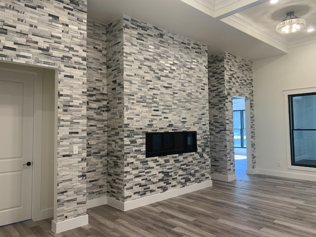 unfurnished living room featuring ornamental molding, baseboards, and wood finished floors