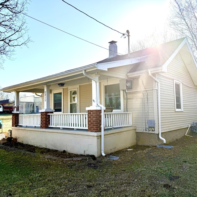 exterior space featuring covered porch and a chimney