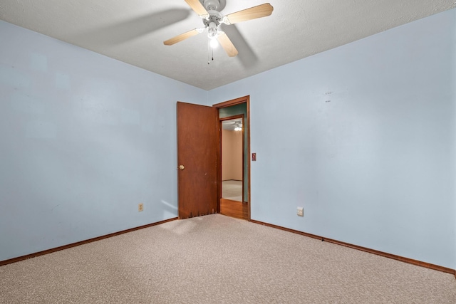 carpeted empty room featuring baseboards and ceiling fan