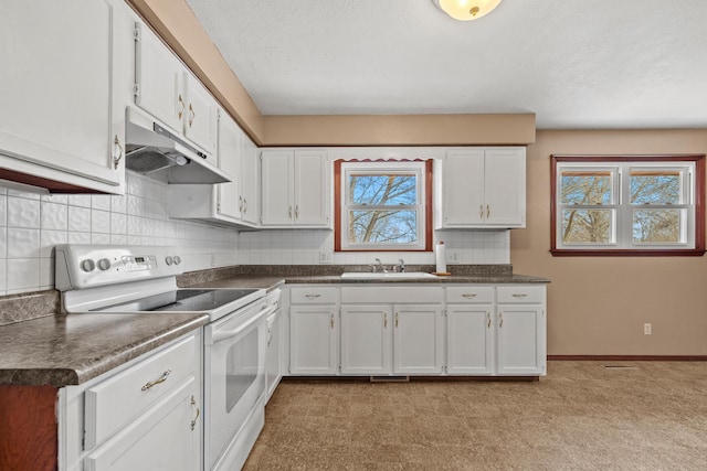 kitchen featuring a sink, white cabinets, under cabinet range hood, dark countertops, and white range with electric stovetop