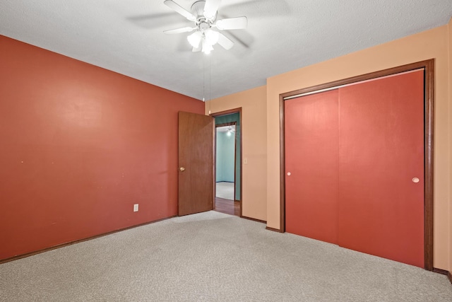 unfurnished bedroom with a closet, a textured ceiling, ceiling fan, and carpet flooring