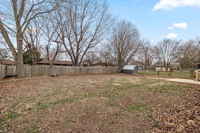 view of yard featuring a storage unit, a fenced backyard, and an outdoor structure