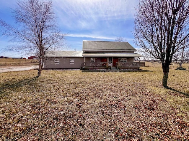 view of front of house with a porch, a front yard, and metal roof