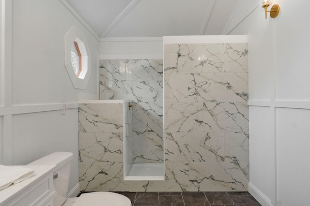 bathroom with vanity, a marble finish shower, lofted ceiling, ornamental molding, and toilet