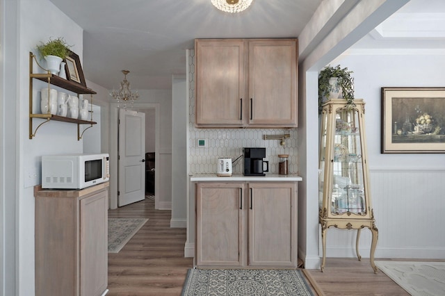 kitchen with light wood-type flooring, open shelves, tasteful backsplash, light countertops, and white microwave