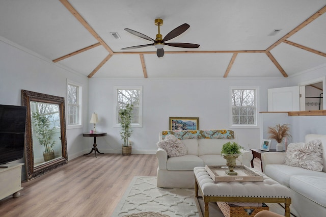 living room with visible vents, plenty of natural light, lofted ceiling, and wood finished floors