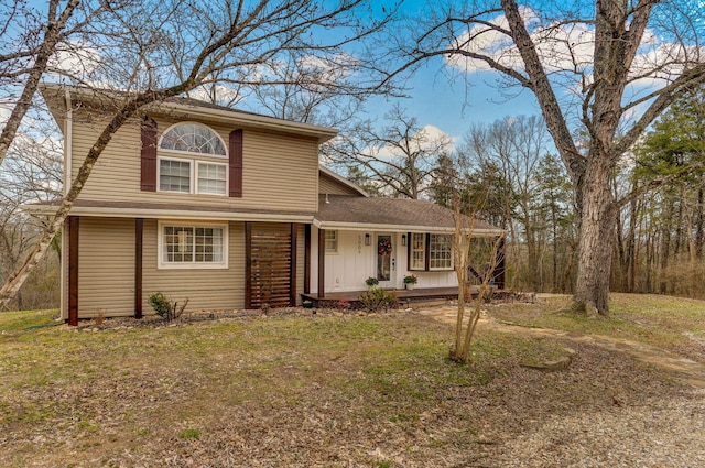 traditional-style house with covered porch and a front lawn