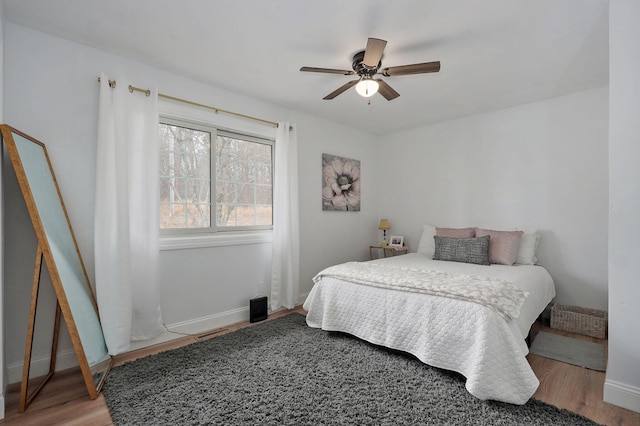 bedroom featuring ceiling fan, baseboards, and wood finished floors