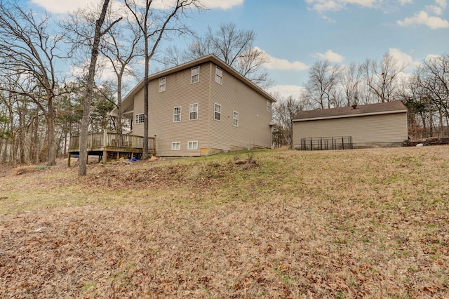 rear view of property with a lawn and a wooden deck