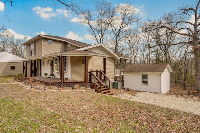 view of front of property with central air condition unit, an outbuilding, a porch, and a shed