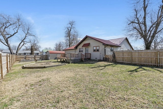 view of yard with a fenced backyard, an outdoor structure, and a deck