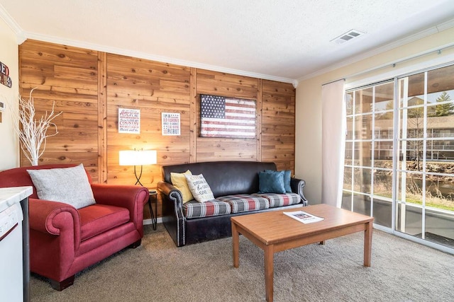 carpeted living area featuring visible vents, a healthy amount of sunlight, a textured ceiling, and ornamental molding